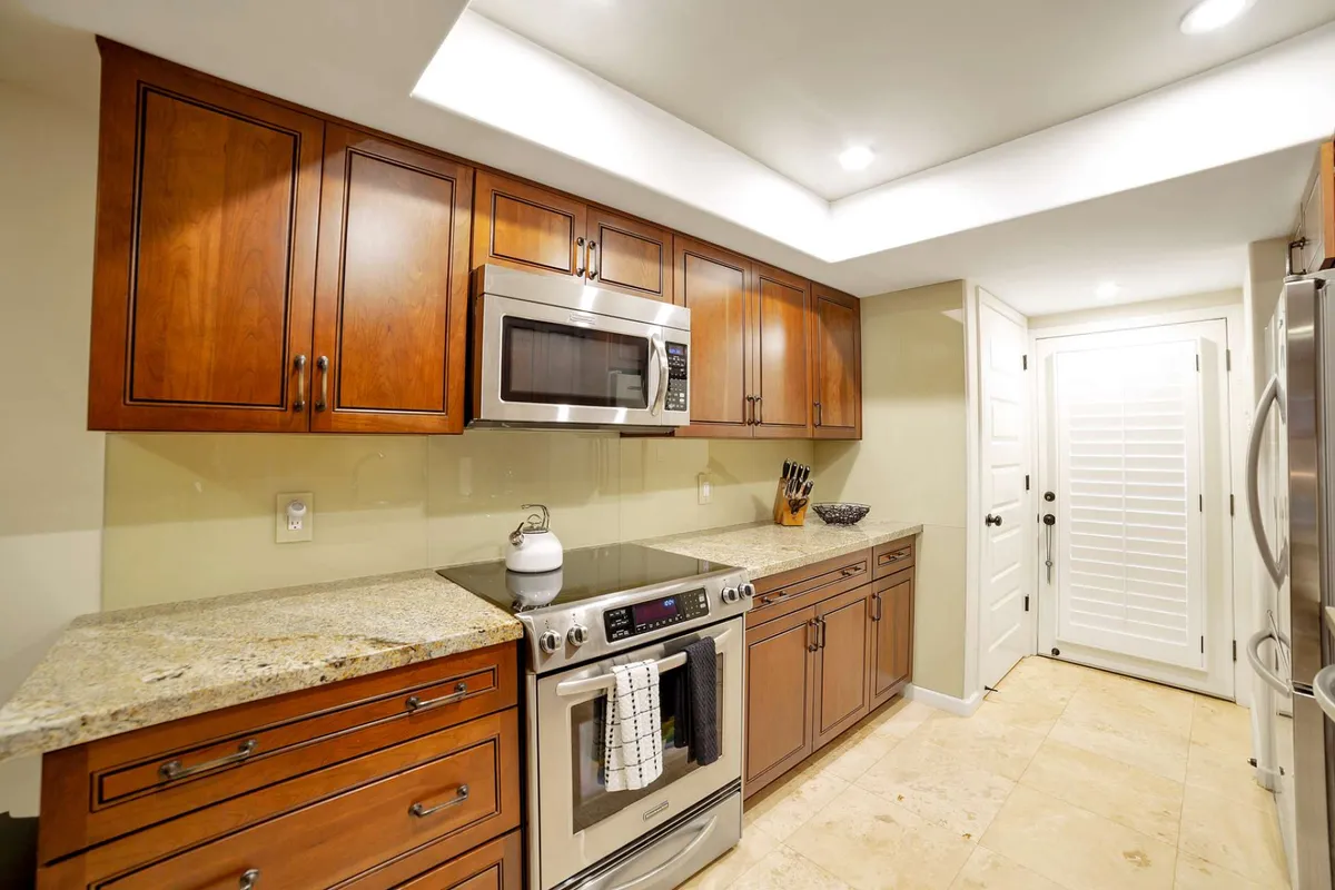A cozy, inviting kitchen with granite countertops, stainless steel appliances, and wooden cabinets. The space is well-lit and arranged for cooking, entertaining, and sharing meals, offering a glimpse into the heart of the home's communal activities.